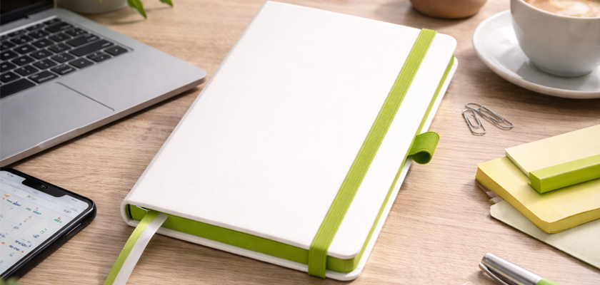 Записна книжка A5 Blanco з зеленою резинкою на робочому столі з ноутбуком та кавою