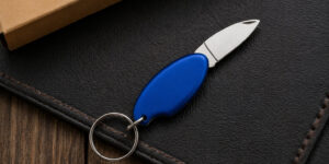 Брелок для ключів Drop TM Discover з металевим лезом на темній поверхні, синій корпус