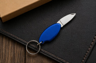 Брелок для ключів Drop TM Discover з металевим лезом на темній поверхні, синій корпус