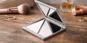 Компактне складне дзеркало Glaz TM Discover у відкритому вигляді на дерев’яній поверхні