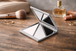 Компактне складне дзеркало Glaz TM Discover у відкритому вигляді на дерев’яній поверхні