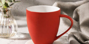 Керамічне горнятко Velvet ТМ Discover з soft-touch покриттям червоного кольору на столі