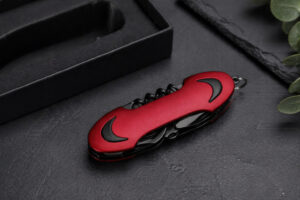 ніж Flint TM Discover багатофункціональний червоний у закритому вигляді на темному фоні