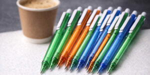 Ручка кулькова пластикова New York поруч із стаканом кави, набір з 15 рекламних ручок як альтернатива вартості кави