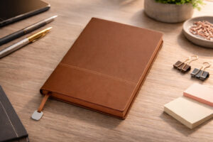 записна книжка A5 Malaga коричнева з м’якою обкладинкою та пофарбованими торцями сторінок на робочому столі